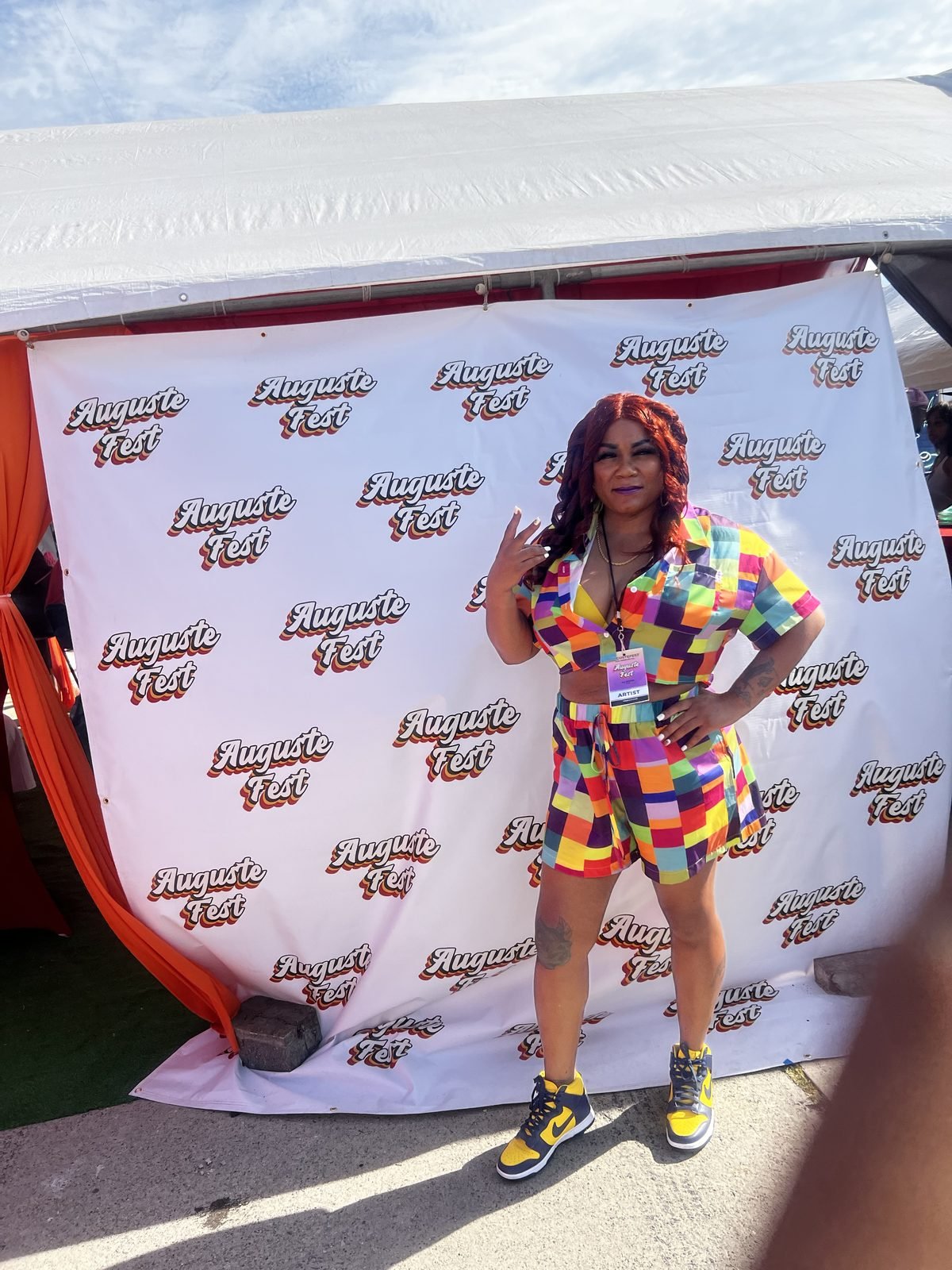 Jay Plush at an outdoor step-and-repeat in a colour-block set